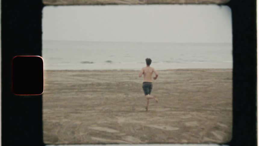 Man runs over the sand towards the ocean