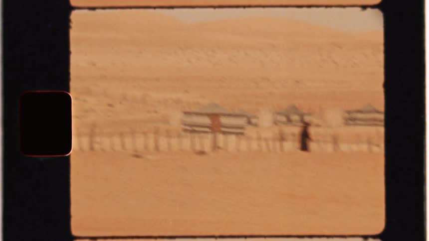 People are walking in the desert near a road in the middle east during the day