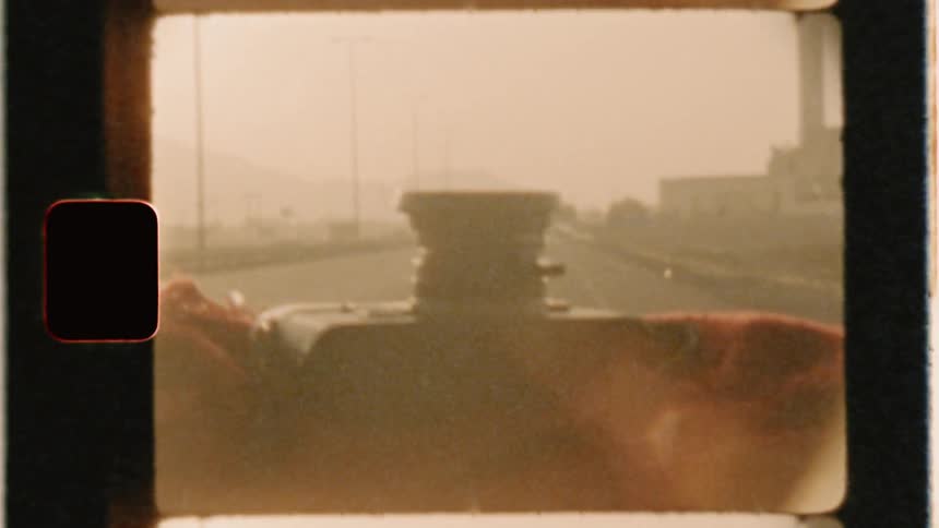 A camera sits lens up on a moving car dashboard
