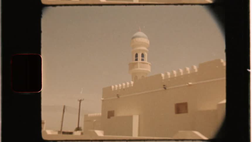 A car drives by a white building
