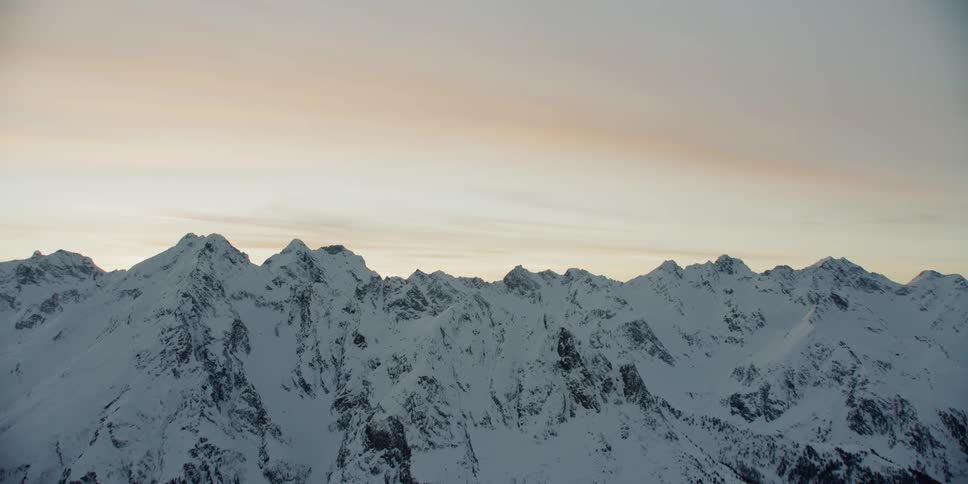 Snow covered mountain ridge at sunset