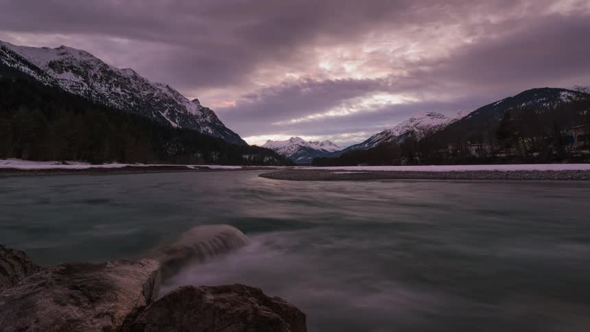 Clouds float over a mountain lake at sunset