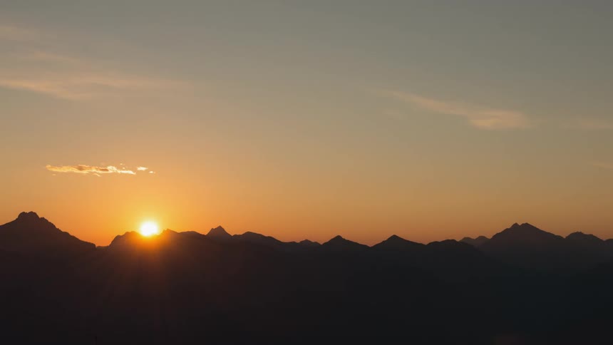 The sun rises from behind the mountain