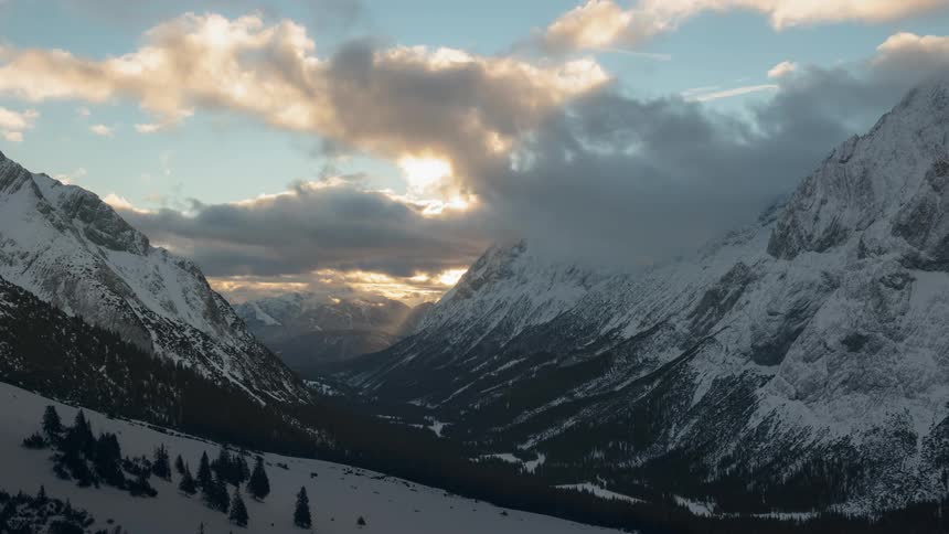 Clouds pass above the snowy mountains