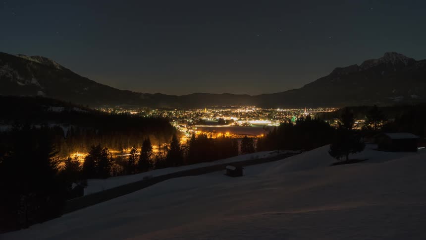 Cars drive on a mountain road at night