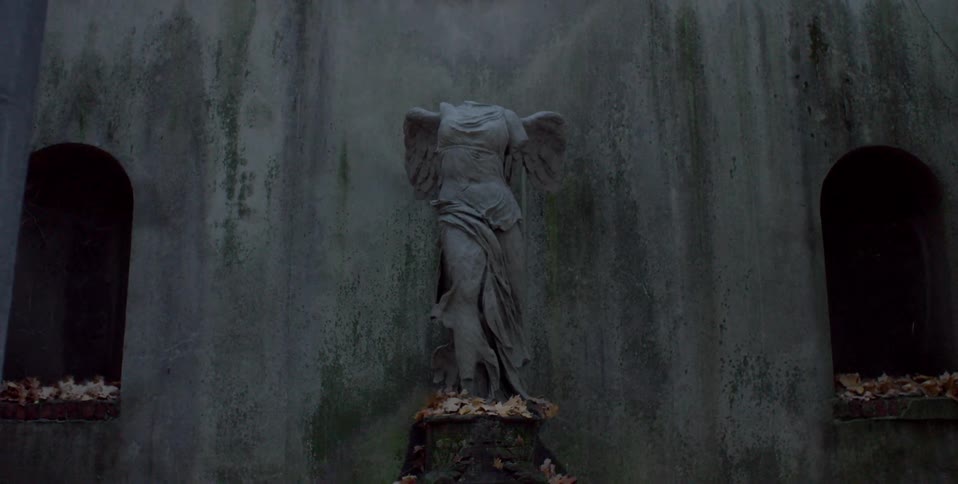 Fall leaves surround a headless angel statue