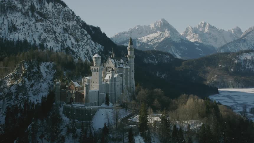 A large castle building sits atop the mountain