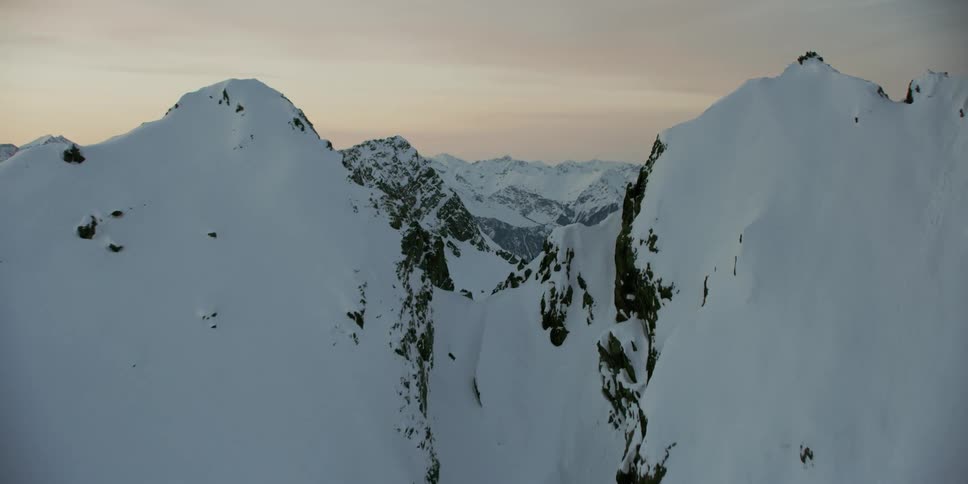 Snow covered mountain ridges and peaks at sunset