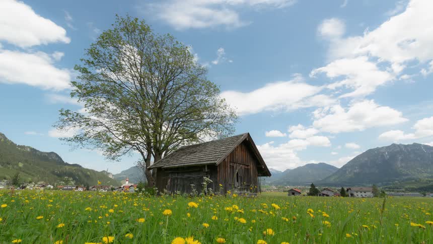 Clouds float over a building in a field