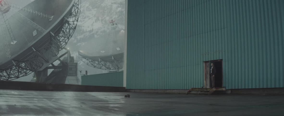 Man leaves a building near large satellites