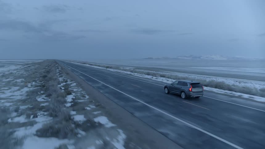 Car drives on a rural road at sunset
