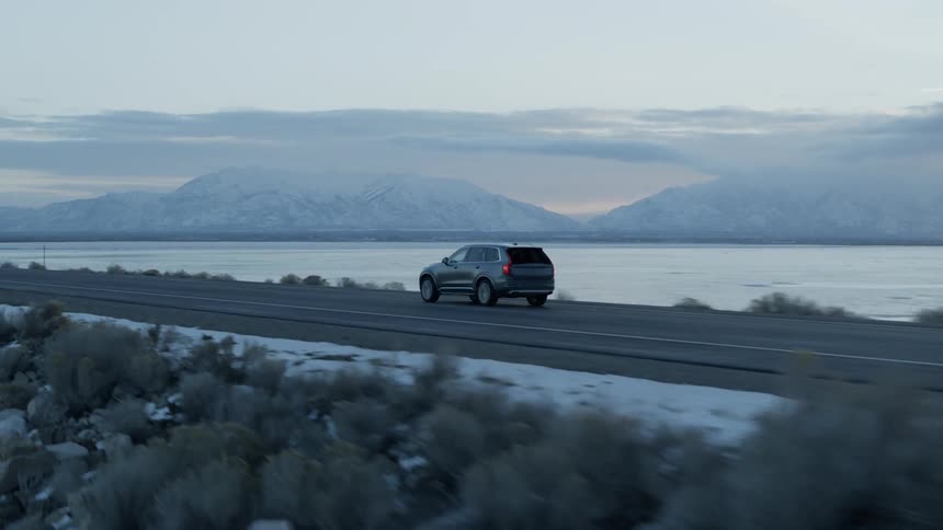 Vehicle travels down a highway under a cloudy sky