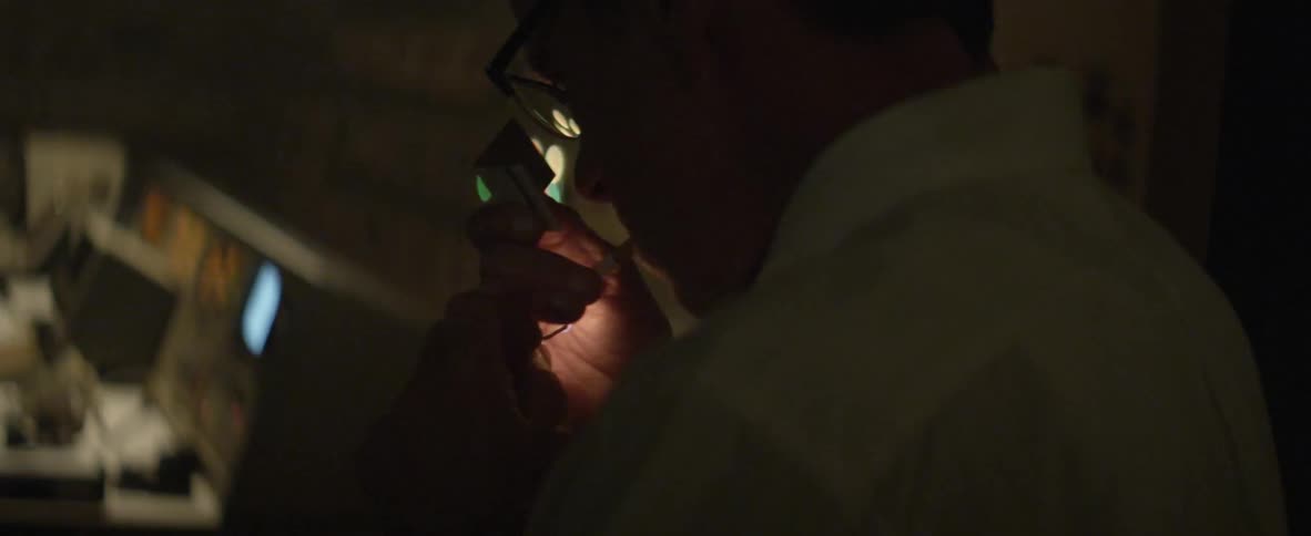 A man lighting a cigarette in a computer processing room