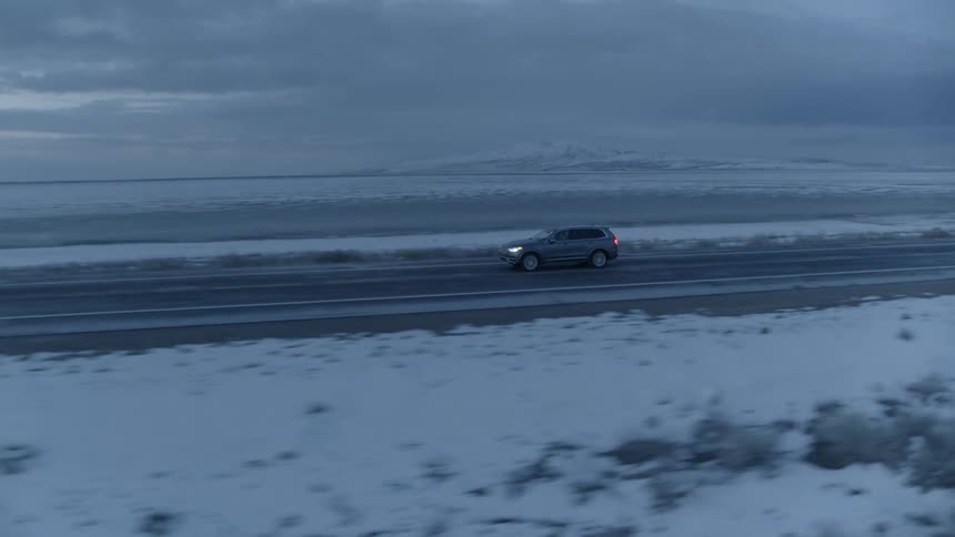 An suv travels on a rural road on a winter day