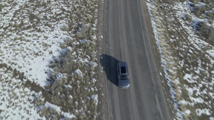 A car drives down a rural road