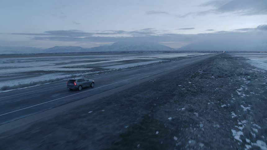 Car travels on a rural road at sunset