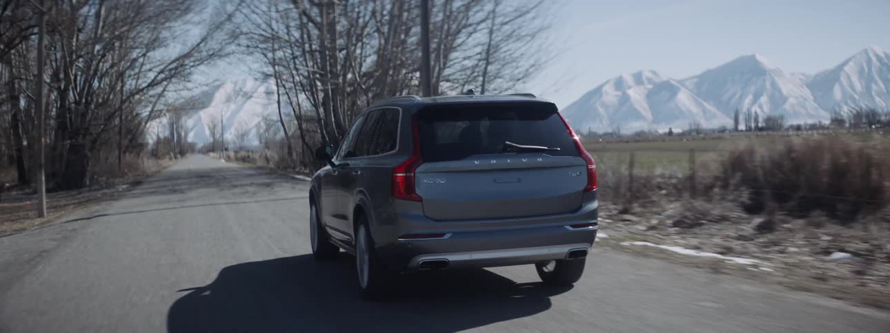 An suv travels on a rural road on a sunny winter day