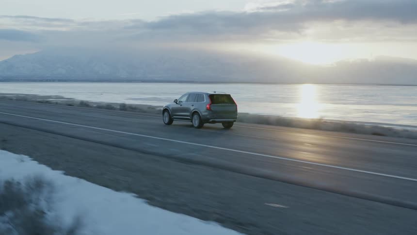 A truck drives on a coastal road