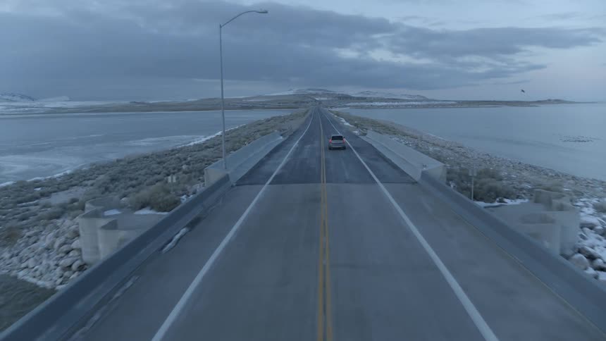 Car drives on a lakeside road