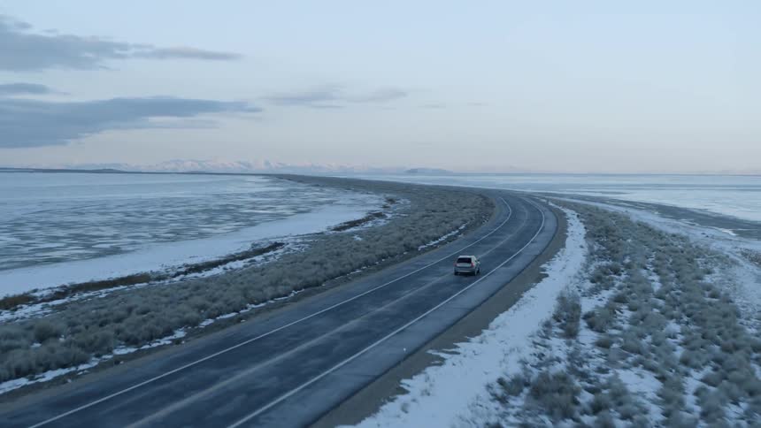 A car drives down a coastal road