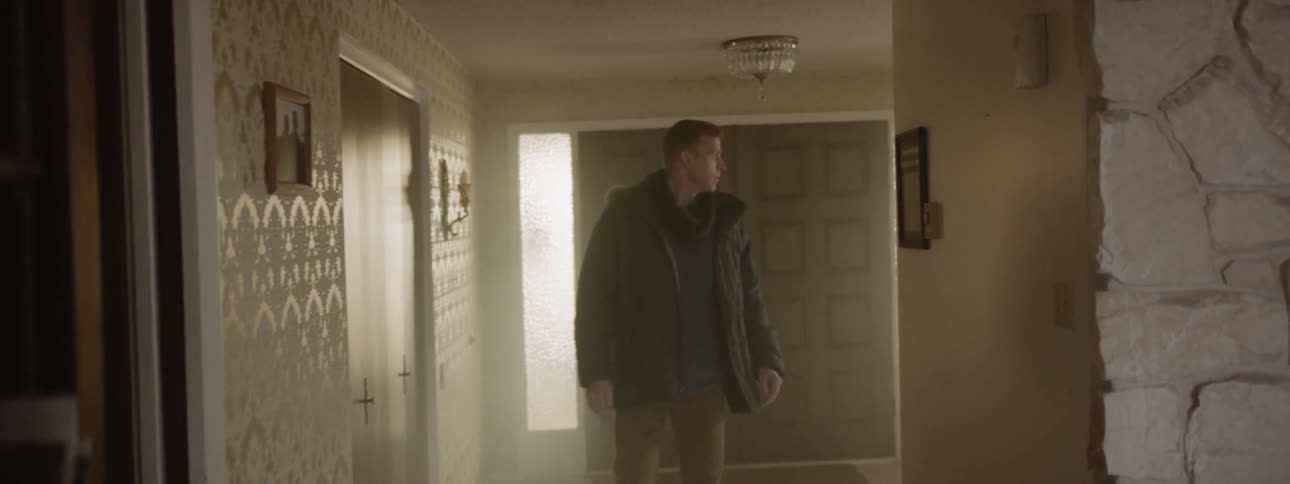 Man walks down a hallway of a house