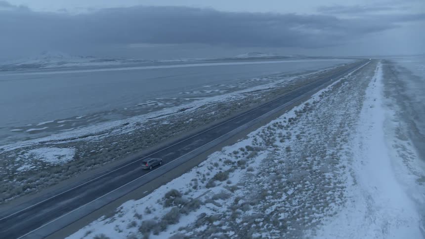 A truck drives on the shoreline road