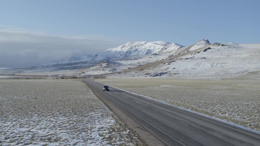 Vehicle travels down a highway under a blue sky