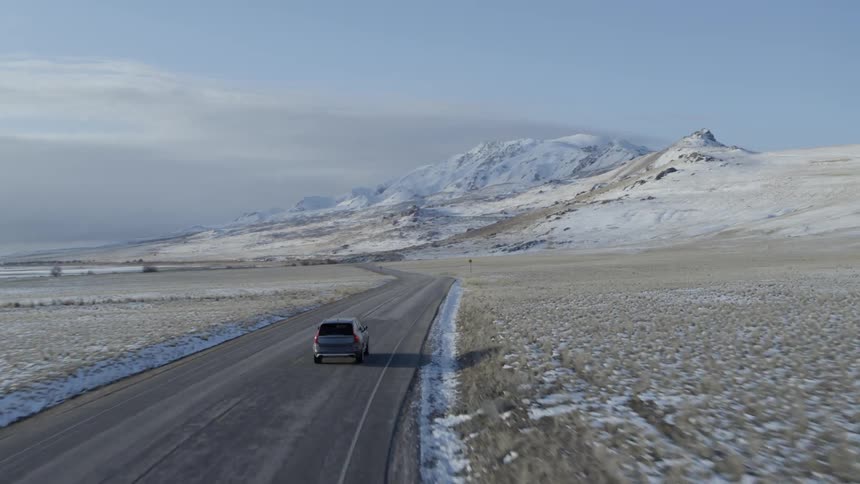 Vehicle drives on a country road in the winter time