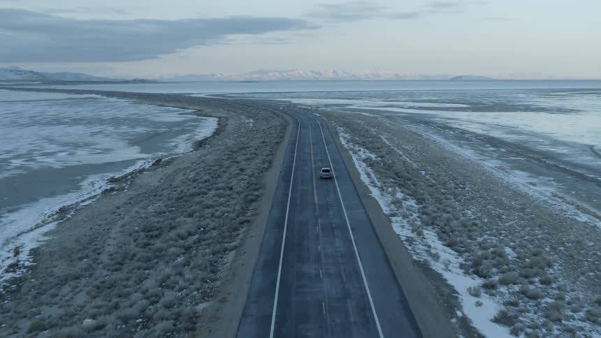 Vehicle travels down a highway under a cloudy sky