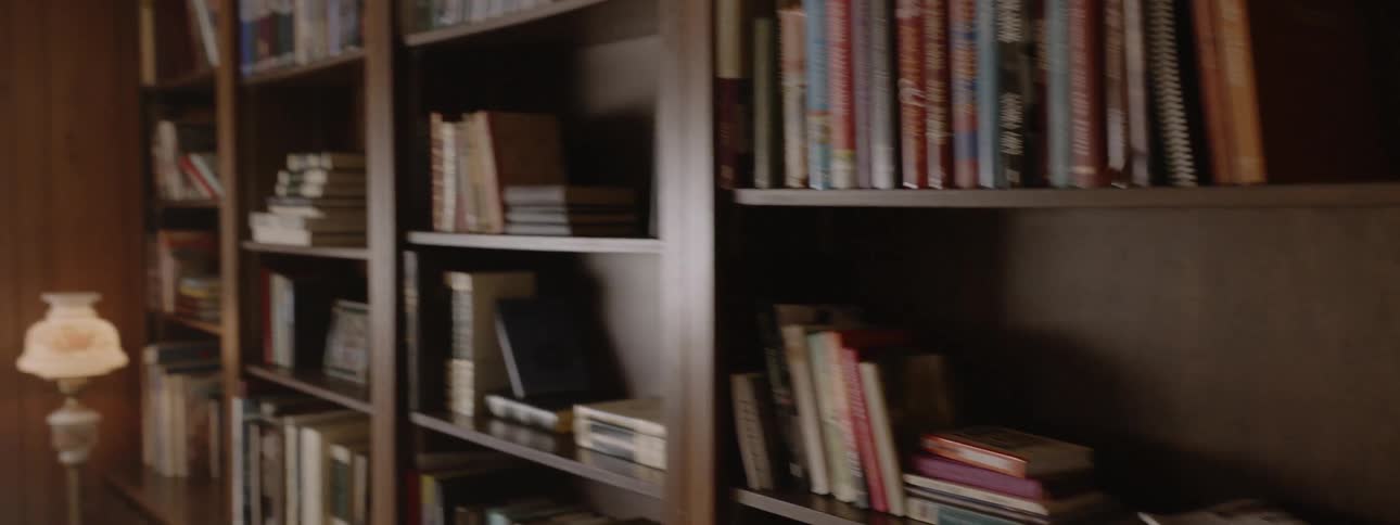 Living room with bookshelves and the hallway of a house