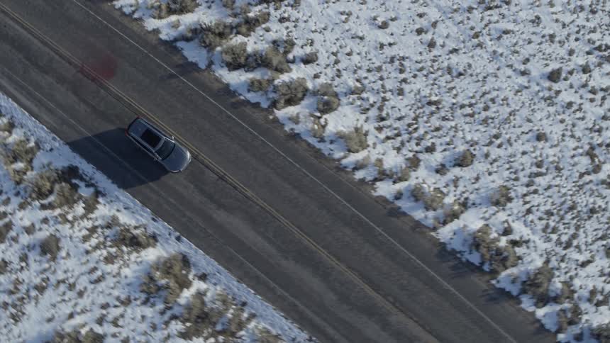 Truck drives down a road in the snowy country