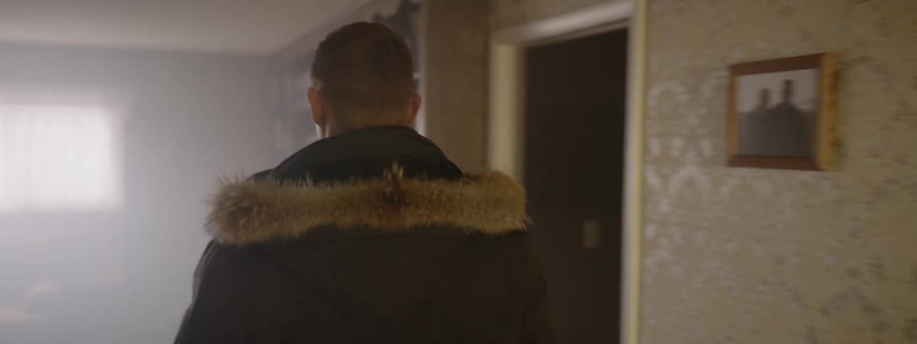 Man walks into a house and walks down the hall