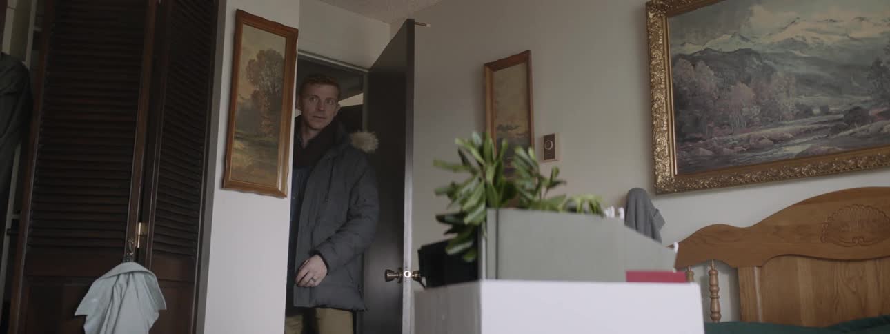 Man opens a door and walks into a room