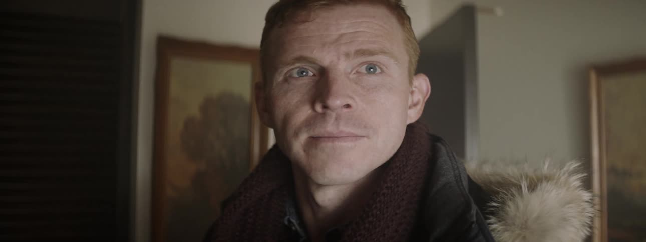 Man wearing a coat looks across a room