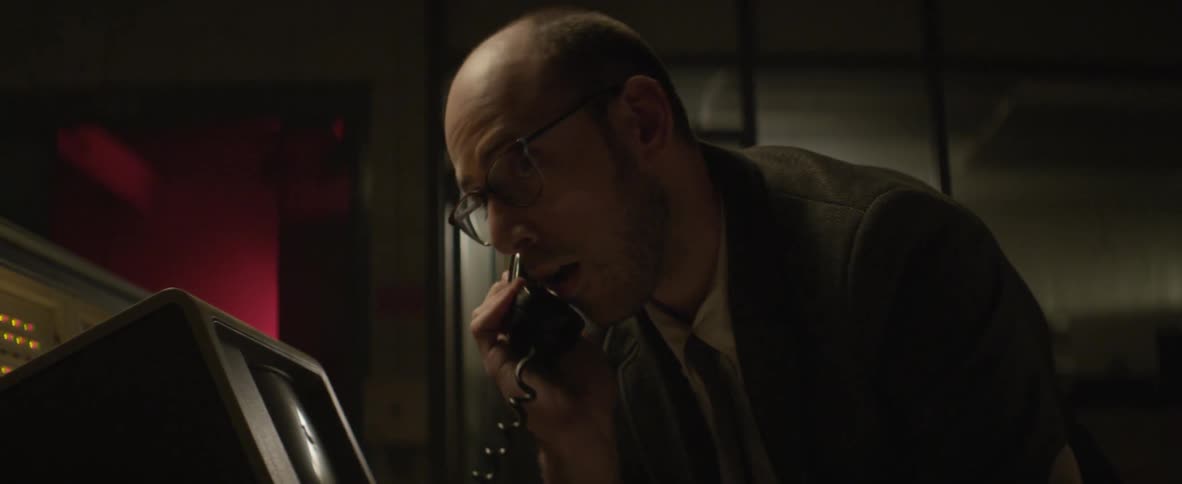 A man in a suit talking on a corded phone
