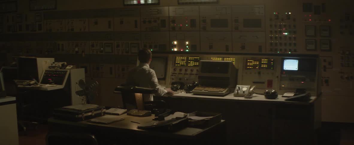 Man typing on a computer by a terminal
