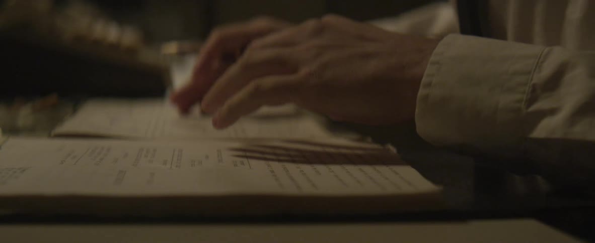 Hands of a man typing and flipping through papers