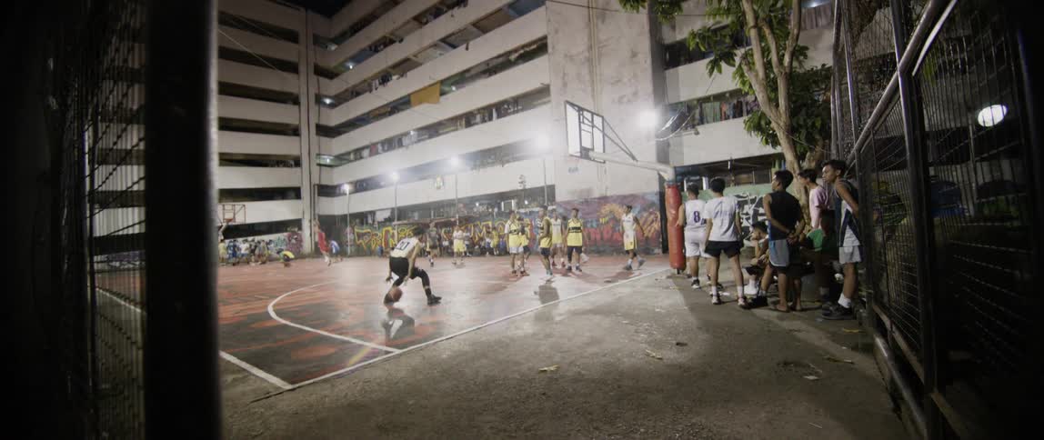 Men play basketball on an outdoor court