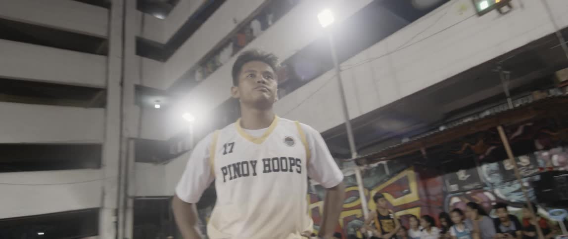 Teenager plays basketball on an outdoor court