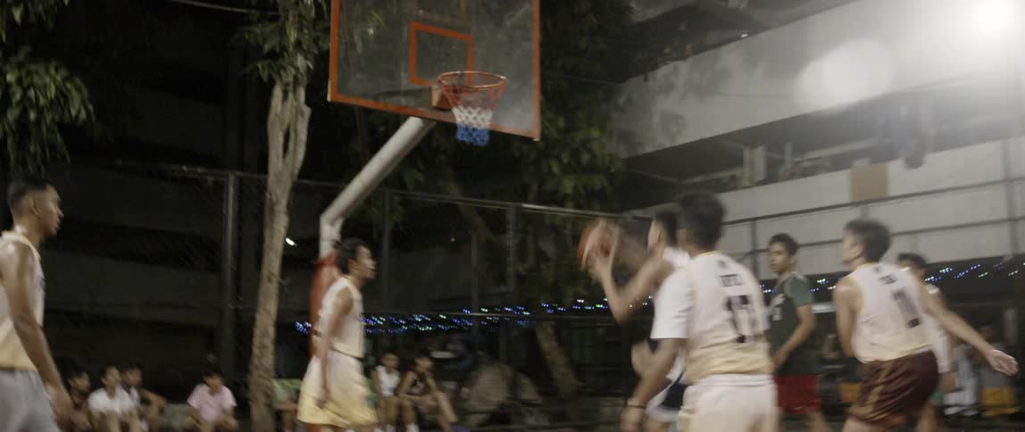 Men play basketball on an outdoor court
