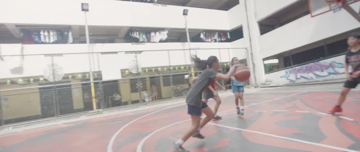 Women play basketball on a basketball court