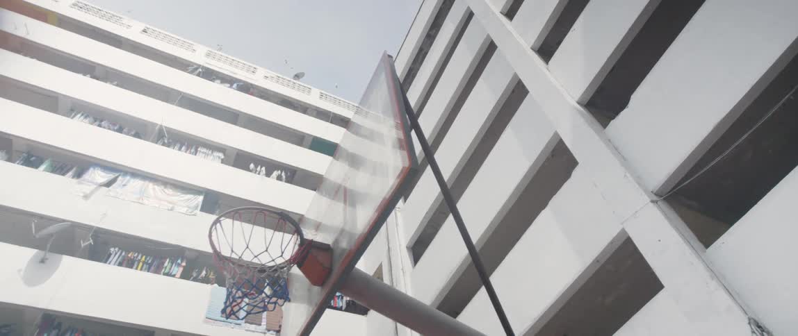 A basketball hoop stands in an apartment courtyard