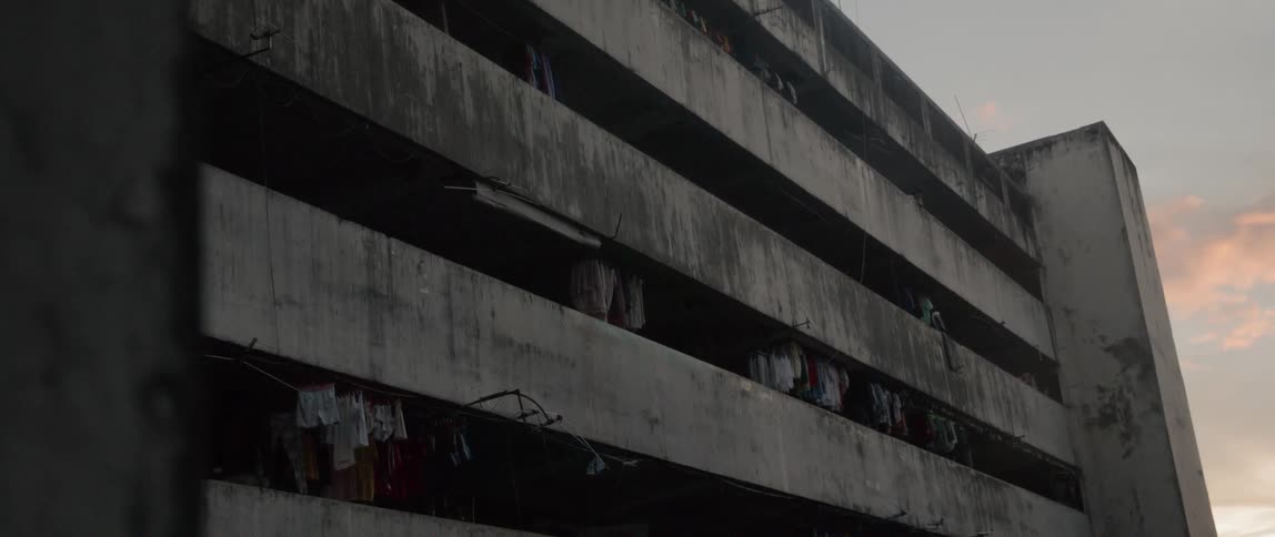Clothes hang in the balconies of a large building