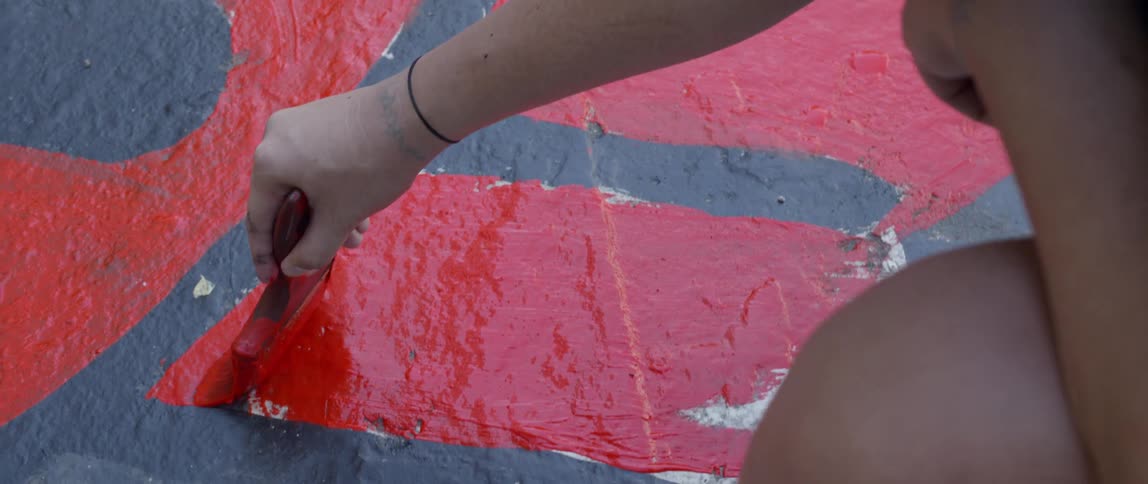 A man painting a red line on the ground outdoors