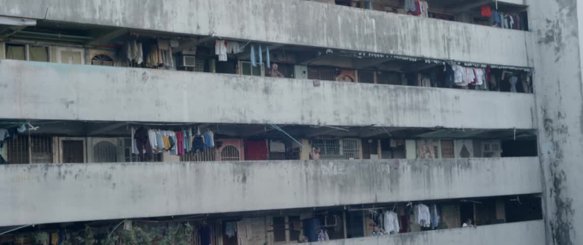 Large concrete building with clothes hanging up on the balcony