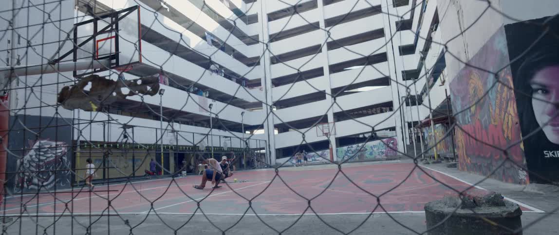 People are on an outdoor basketball court