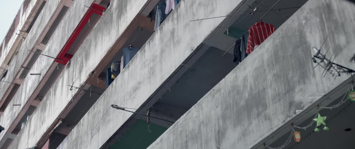 Clothes hang in the balconies of a large building