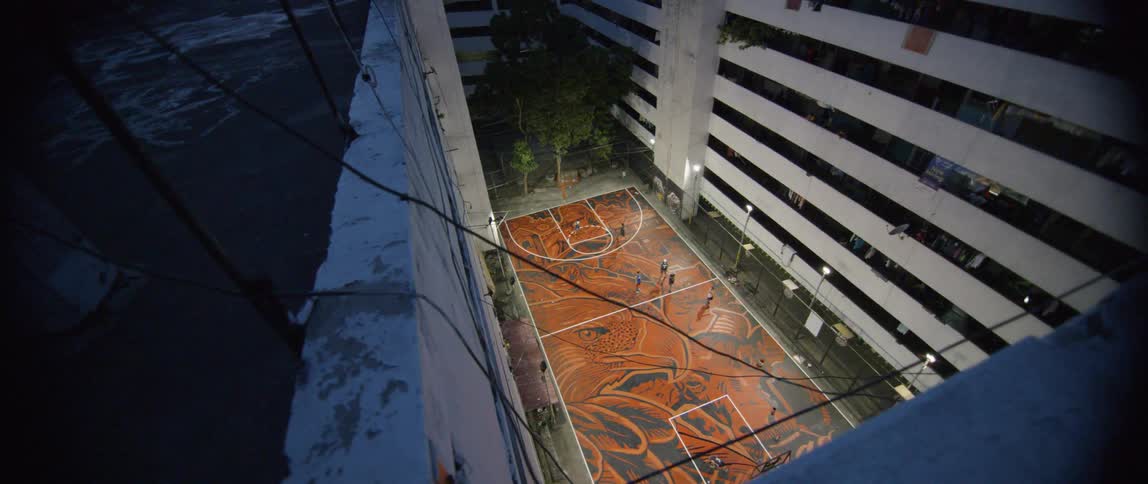 An empty basketball court sits next to a building