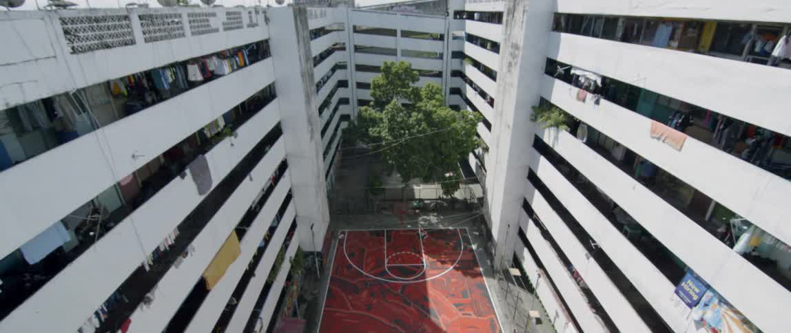 A basketball court sits in an apartment courtyard