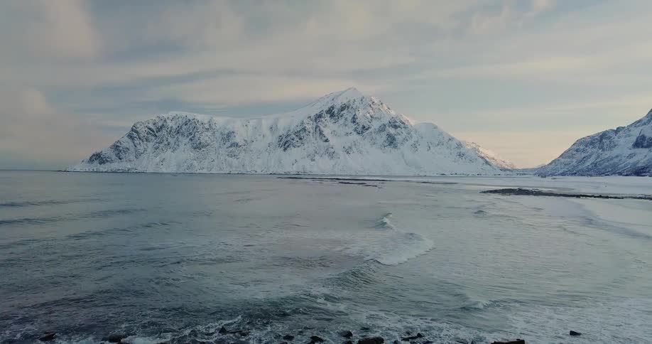 Waves wash ashore a snowy beach